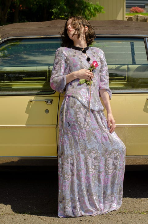 woman leans on car