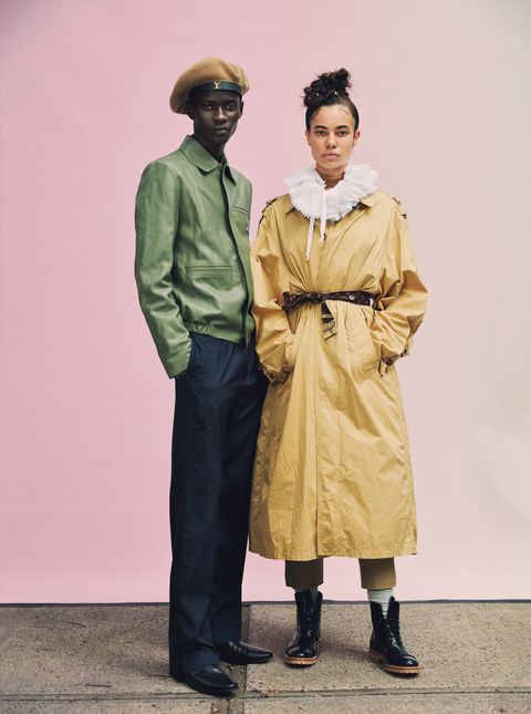 male models poses in green jacket with female model  in khaki trench
