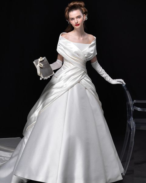 エマリーエ ウェディングドレスサロンのケープカラーのドレスを着たモデルの写真。