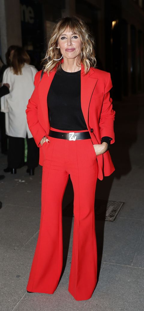 la presentadora con un traje pantalón en color rojo y jersey negro