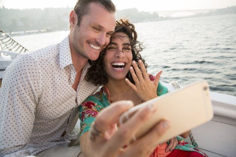 couple on boat showing off engagement ring