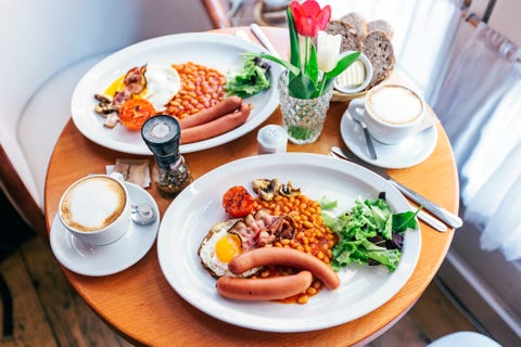 english breakfast with eggs, beans, bacon, sausages, mushrooms and tomatoes