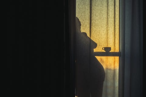 a naked girl is standing by the window behind the curtain