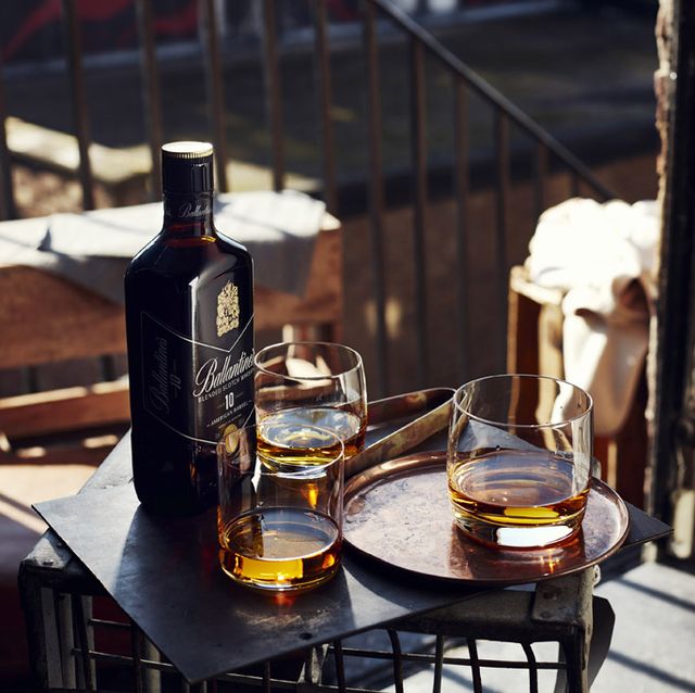 la imagen muestra una botella de whisky y tres vasos para ilustrar un artículo sobre formas de preparar una copa de ballantine's 10 new barrel