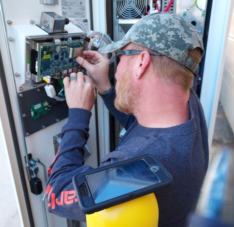 a charge enterprises worker performs maintenance on an ev charger from charge enterprises