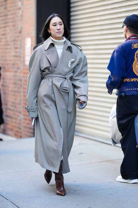 vrouw in oversized trenchcoat met broche street style february 2023 new york fashion week