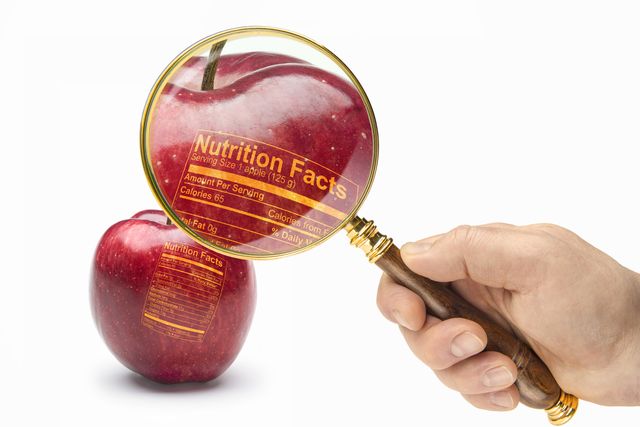 examinado con una lupa las propiedades nutritivas de una manzana