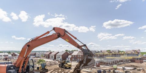Excavator moving earth on housing building site