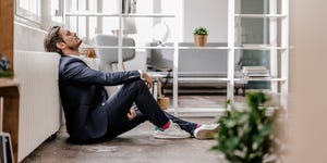 Exhausted businessman sitting on the floor