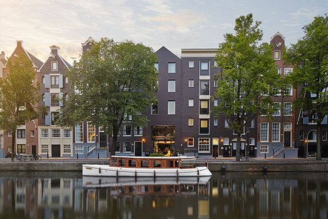 canal houses and boat in amsterdam