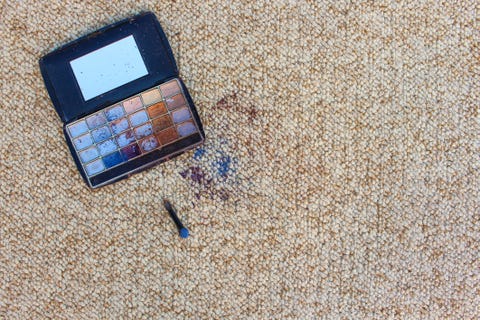 eye shadow fell and scattered on carpet top view