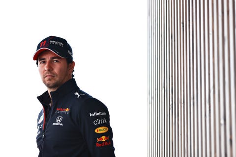 f1-föraren sergio 'checo' perez i red bull racing team kit, står ensam i paddocken