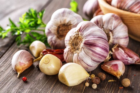 fresh garlic bulbs and garlic cloves on wooden table