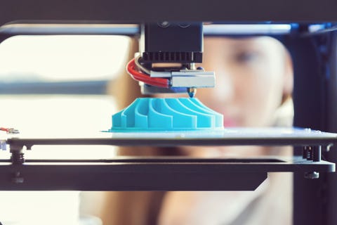 3D printout young woman watching 3d printout focus on blue printout