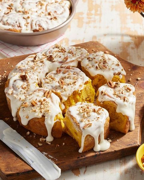 pumpkin spice cinnamon rolls with frosting and nuts