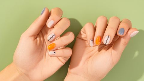 close up womans hands with trendy minimal manicure on green background spring summer nail design beauty salon concept