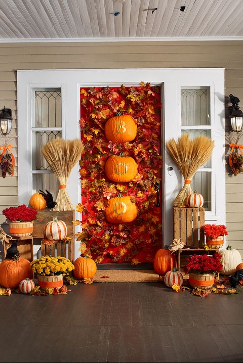 fall porch ideas decorated front door with leaves and pumpkins, surrounded by floors and pumpkins