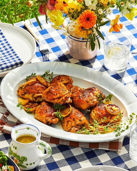 fall recipes lemony chicken thighs arranged in an oval serving platter with thyme and lemon slices