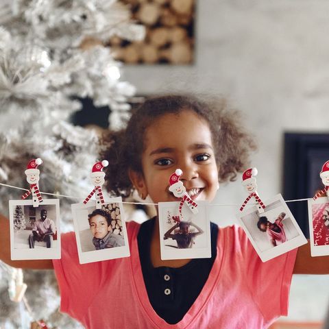 girl with photos attached to string with snowman paperclips