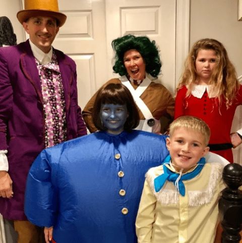 a family halloween costume inspired by 'willy wonka and the chocolate factory' including willy wonka, an oompa loompa, veruca salt, violet beauregard and mike tv