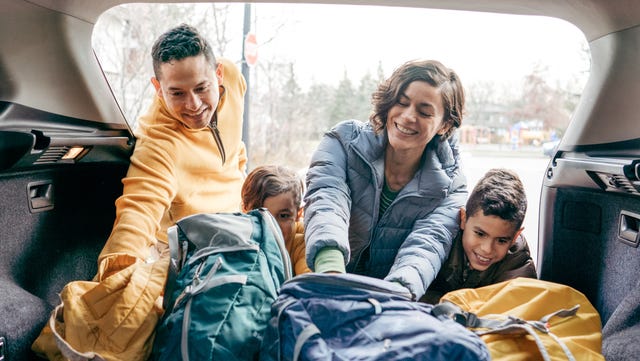 famille chargeant un coffre de voiture avant le road trip