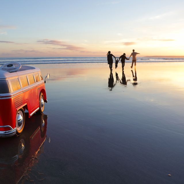 Family on beach at sunset with toy car