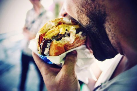 Hardloper eet cheeseburger en dat is niet zo gezond 