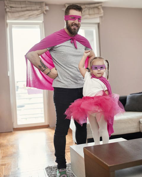 father and daughter playing superhero and superwoman