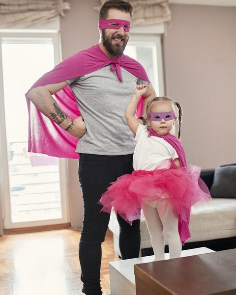 father and daughter playing superhero and superwoman