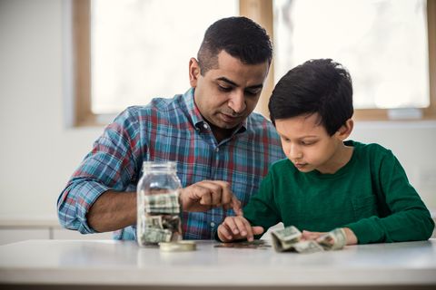 Father and son counting money at home
