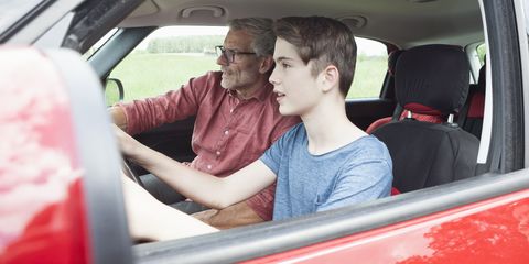 father teaching son driving a car