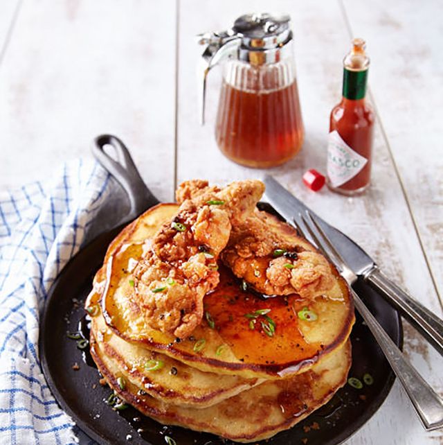 pancakes with fried chicken on top served in a cast iron skillet