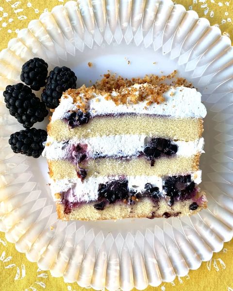 blackberry icebox cake slice on plate with fresh blackberries