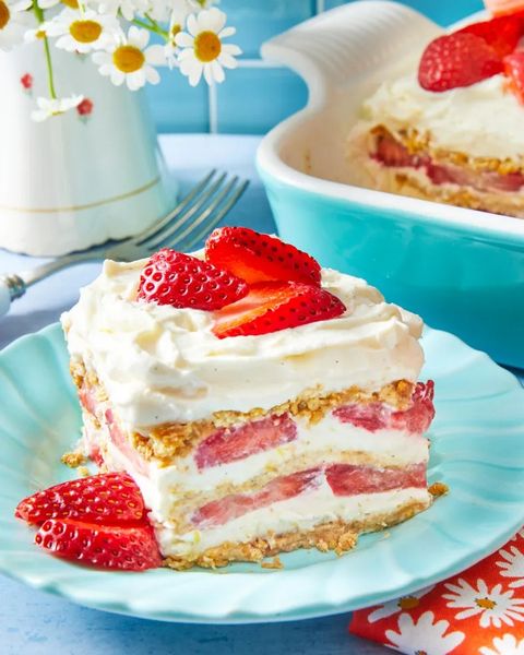 strawberry icebox cake slice on blue plate with flowers in back