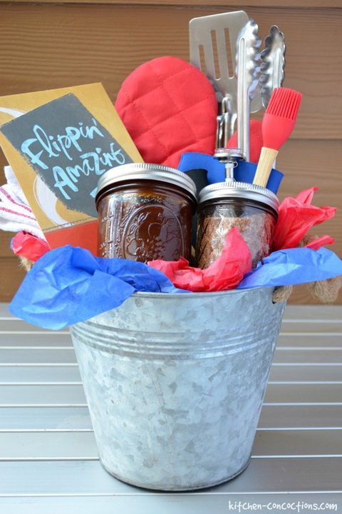 galvanized bucket lined with red and blue tissue paper filled with bbq mitt, basting brush, other bbq tools, dry rub, bbq sauce, and card reading flippin amazing