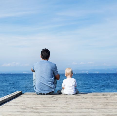 Father with son sitting on the sea pier