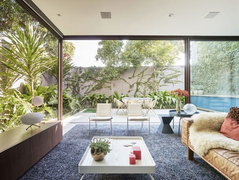 Una casa con arquitectura moderna, patio ajardinado y piscina