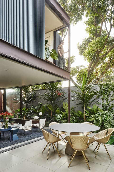 Una casa con arquitectura moderna, patio ajardinado y piscina