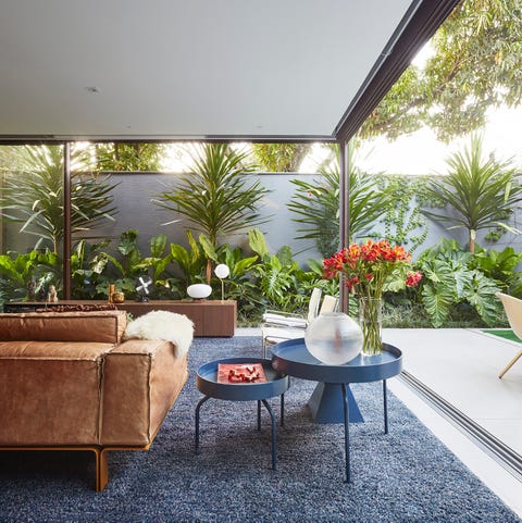 Una casa con arquitectura moderna, patio ajardinado y piscina