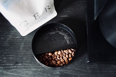 Coffee beans from a fellow Opus grinder on the counter next to a bag of coffee
