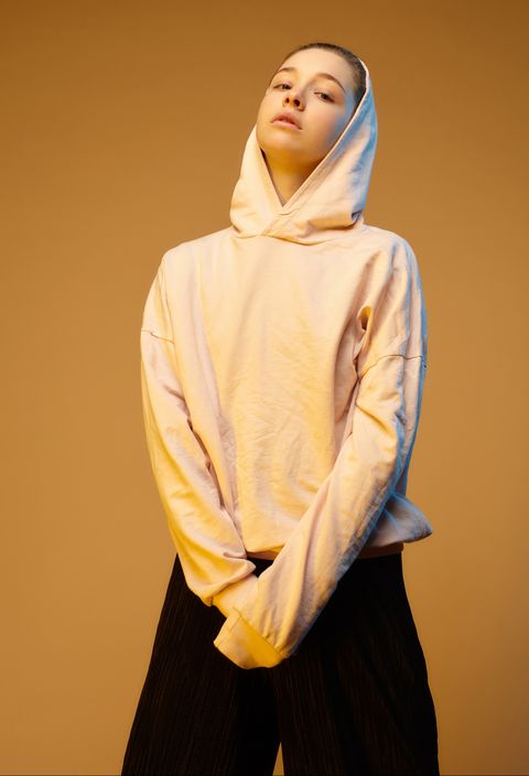 Portrait of young woman wearing hoodie in studio