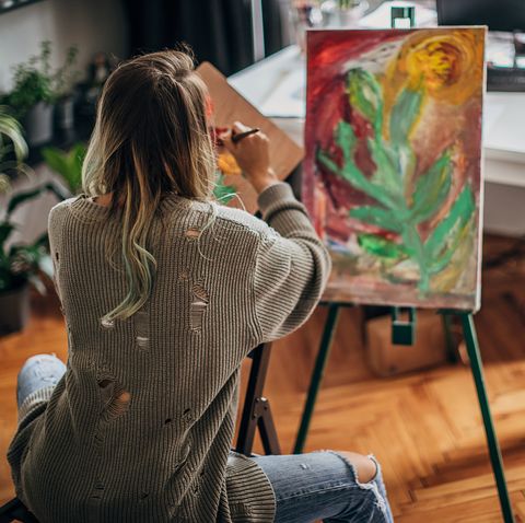 female artist painting in living room