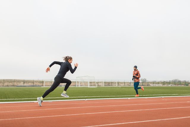 female athlete doing powerful interval running training and speed up on stadium running track