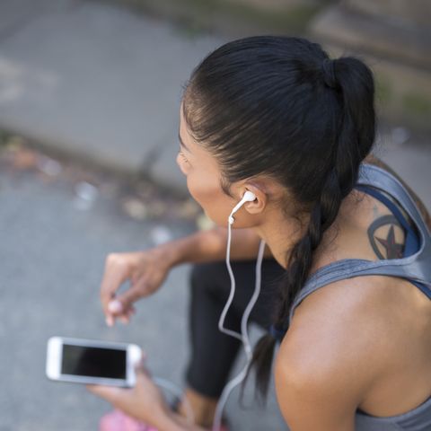 Female athlete listening to music with smartphone