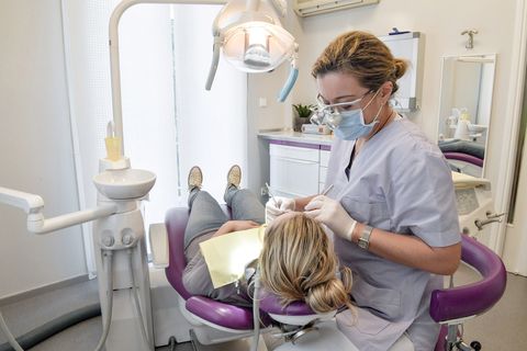 female dentist examines a patient in a dental clinic