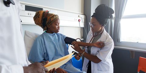 Female Doctor taking blood pressure on patient in a hospital