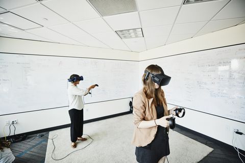 Female engineers using virtual reality headsets to test programs in computer lab