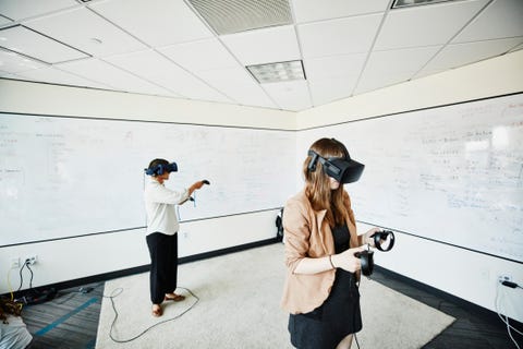 Female engineers using virtual reality headsets to test programs in computer lab