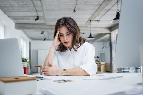 female entrepreneur with headache sitting at desk