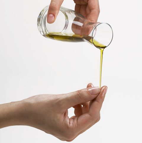 A female hands pouring some oils from a bottle